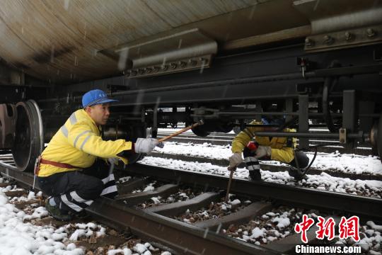 南京東車輛段貨車檢車員風(fēng)雪里按標(biāo)準(zhǔn)作業(yè)，保障運輸安全。　劉寅 攝