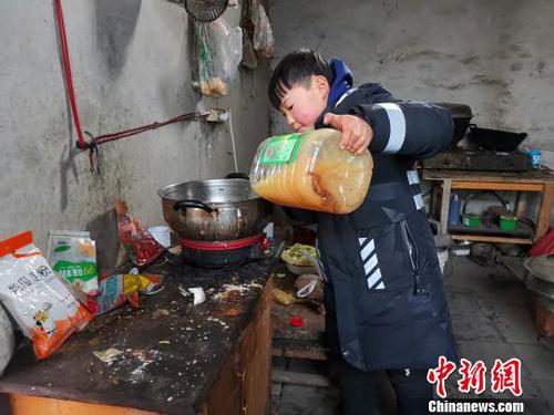 當天中午，劉奉智熟練地切白菜、刷鍋、燒油，燉白菜湯，準備午飯。　郝學娟 攝