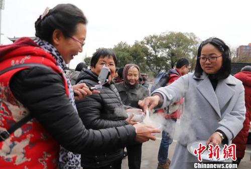 圖為民眾品嘗剛出鍋的湯圓。　胡小麗 攝