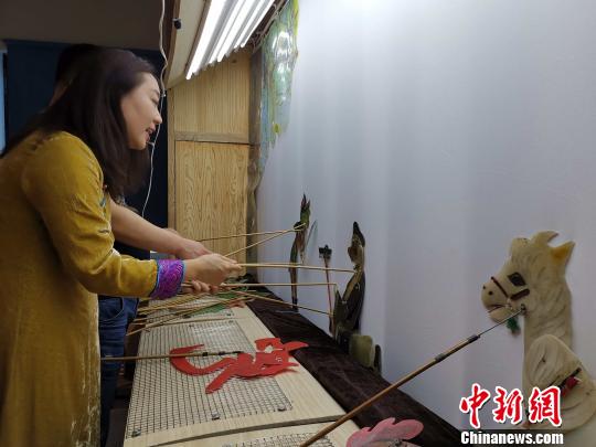 李娟藏在幕布后，繪聲繪色地為觀眾表演《西游記之孫悟空大戰(zhàn)蝎子精》?！≮w曉 攝