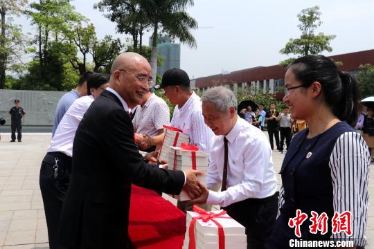 李德文董事長(zhǎng)給學(xué)校老師贈(zèng)送《論語(yǔ)新解》。　魏玥 攝