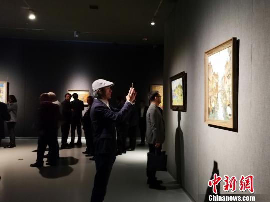 圖為，在“印象山東——俄羅斯油畫家寫生作品展”上，觀眾在喜歡的作品前駐足觀賞、拍照?！O宏瑗 攝