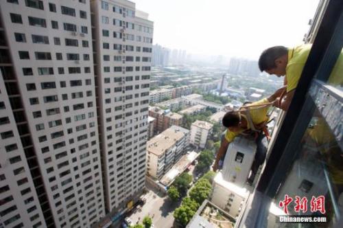 資料圖：在山西太原，空調(diào)安裝工程師頂著酷暑高溫，為市民安裝空調(diào)。<a target='_blank' href='http://www.chinanews.com/'>中新社</a>記者 張?jiān)?攝