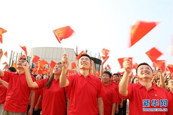 9月26日，在廣東東莞民盈·國貿(mào)中心，粵港澳青年揮舞國旗，合唱《歌唱祖國》。新華社記者 李嘉樂 攝