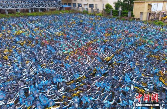 4月4日，航拍江西南昌一共享單車集中停放點，紅、藍、黃、綠等各種顏色、各類品牌的共享單車，密密麻麻地排列在一起，場面十分壯觀。隨著共享單車數(shù)量的猛增，出現(xiàn)了亂停亂放、影響交通秩序，存在安全隱患等問題。這些城市的廢舊共享單車集中停放點，有人把它形象地叫做“共享單車墳場”。劉占昆 攝