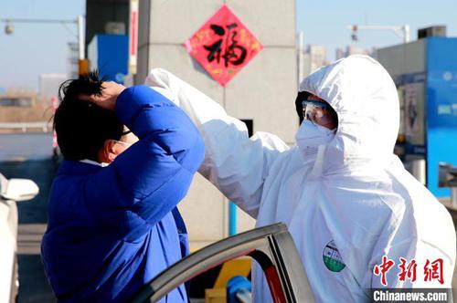 資料圖：圖為防疫人員正在為過往車輛司機(jī)測(cè)量體溫。　梁犇 攝