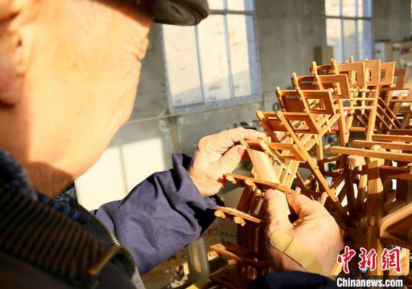 圖為段怡村正在進(jìn)行黃河水車制作。　高康迪 攝