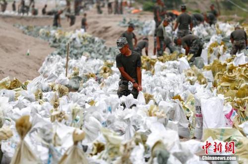 資料圖：7月25日，江西省九江市柴桑區(qū)江洲鎮(zhèn)北堤，中國(guó)人民解放軍第71集團(tuán)軍某部官兵正在為防洪備料。