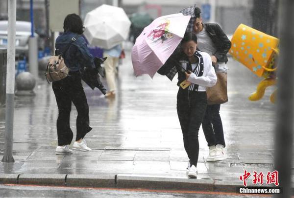 資料圖：市民頂風(fēng)冒雨出行。 中新社記者 張瑤 攝