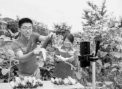 山西平順縣南坡村大學(xué)生王亞鵬（左）回村創(chuàng)業(yè)成為“新農(nóng)人”，圖為他正在直播銷售農(nóng)產(chǎn)品。新華社發(fā)