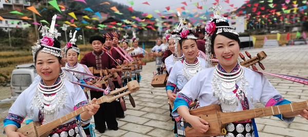 （4月14日，龍勝縣龍脊鎮(zhèn)金江村，侗族同胞彈唱侗族琵琶歌，歡迎農(nóng)歷三月三。 周恩平攝）